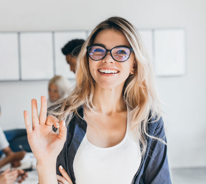 Smiling woman showing an OK sign, symbolizing confidence in professional website maintenance services